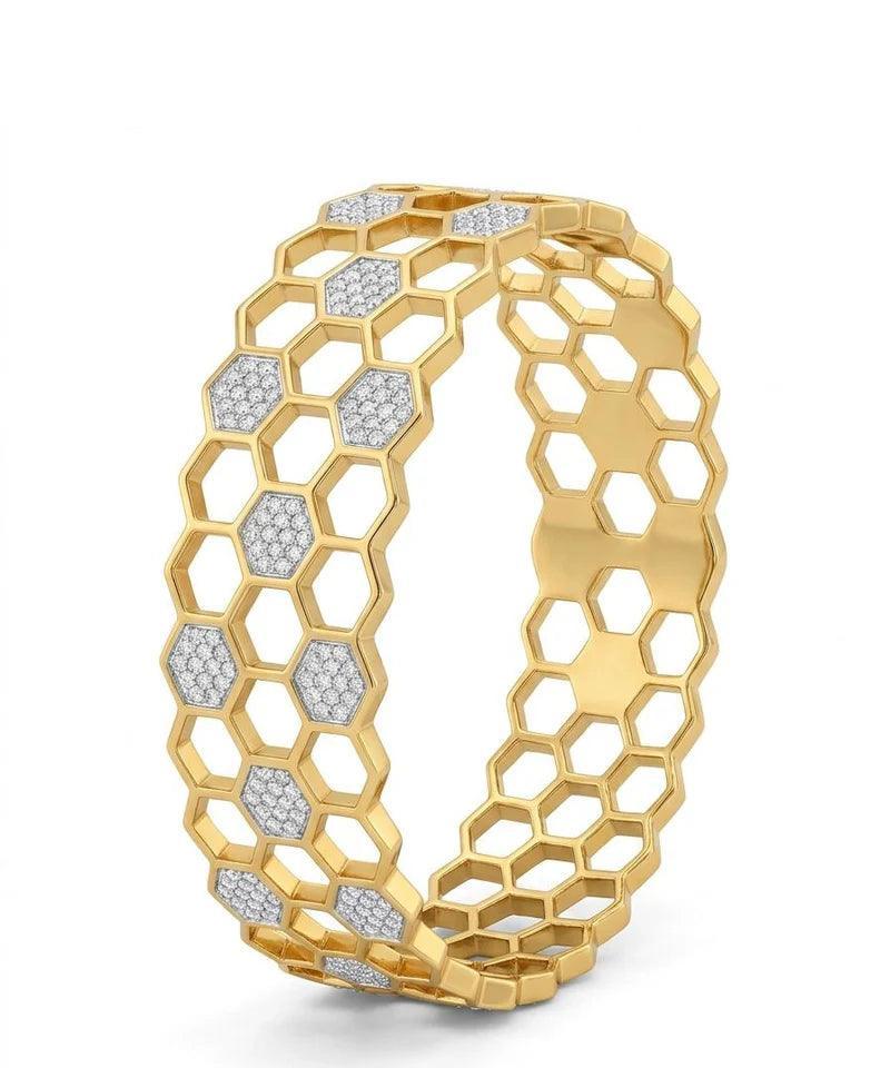 Gold bracelet with honeycomb design and embedded diamonds on a white background