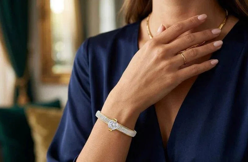 Woman wearing a diamond bracelet and ring, with a blurred indoor background