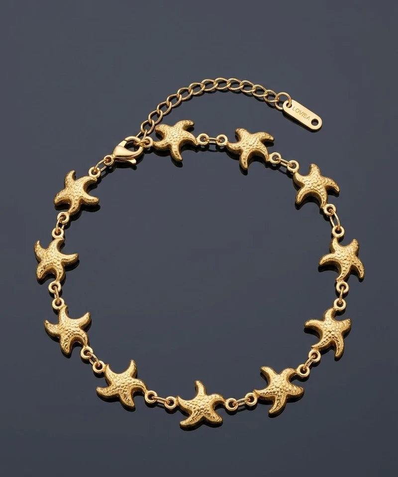 A gold starfish link bracelet arranged in a circle on a dark gray background.