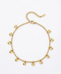 A gold-toned beaded necklace with small sunburst disc charms, displayed on a clean white background.