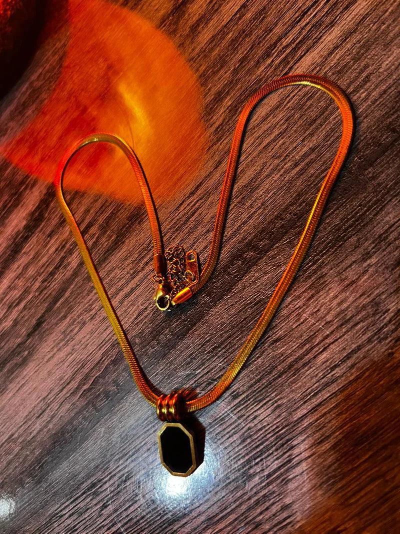 Gold necklace with a pendant on a wooden surface
