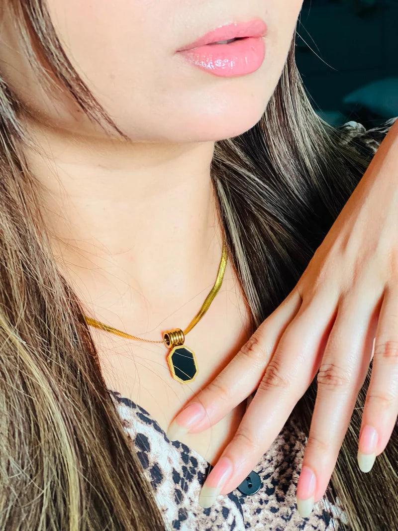 Close-up of a person wearing a necklace with a pendant, focusing on the jewelry.