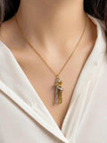 A close-up of a model wearing a delicate gold chain necklace with a unique pendant shaped like two intertwined figures in gold and silver.