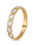 A gold bangle bracelet featuring a row of rectangular clear crystals in gold bezel settings, shown on a plain white background.