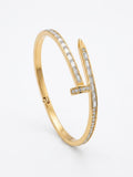 A gold hinged bangle bracelet featuring a stylized 'V' design paved with small clear baguette and round-cut stones, shown on a clean white background.
