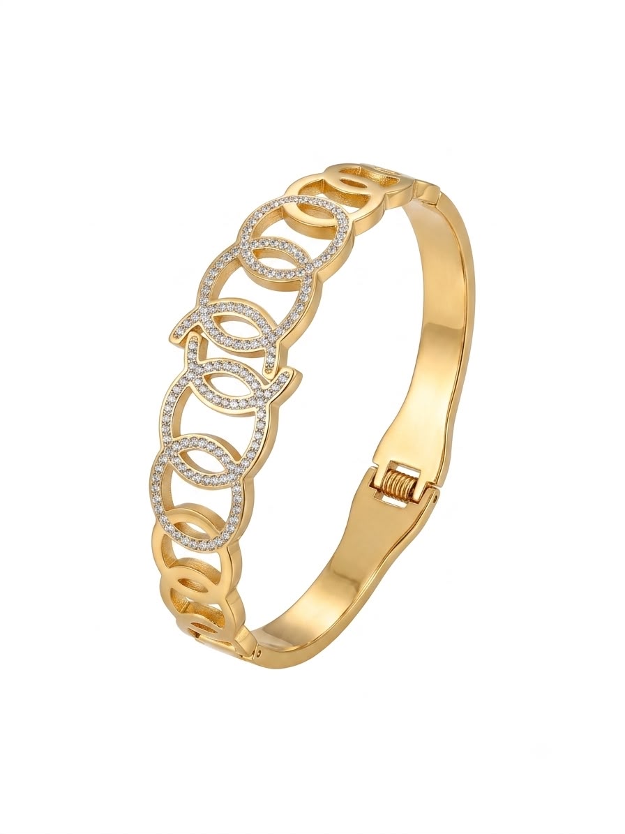 A gold bangle bracelet featuring a central decorative band of interlocking oval links embellished with small clear stones, shown on a plain white background.