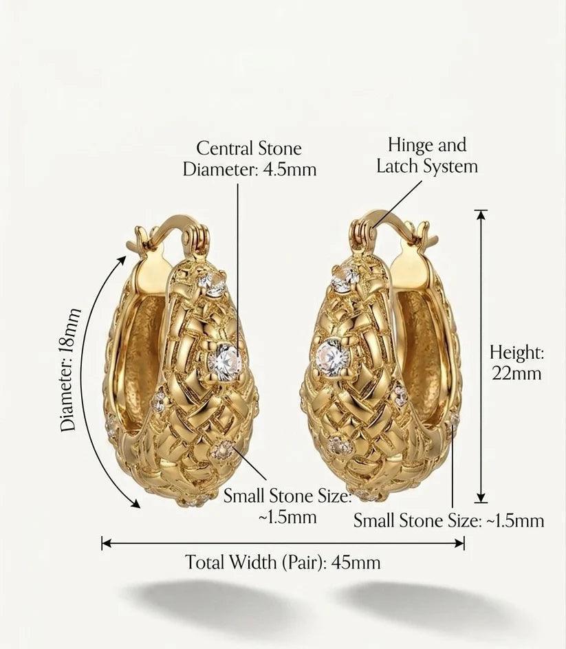 Gold huggie hoop earrings with detailed textured patterns and clear rhinestones, annotated with dimensions and labels showing measurements like central stone diameter, height, and total width on a light background.