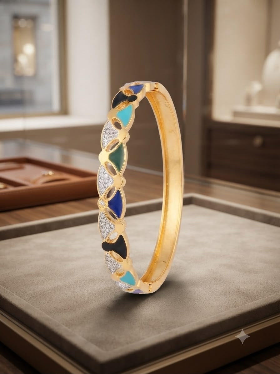 A gold bangle bracelet with intricate enamel and stone detailing, displayed on a gray velvet jewelry box in a luxury boutique setting.