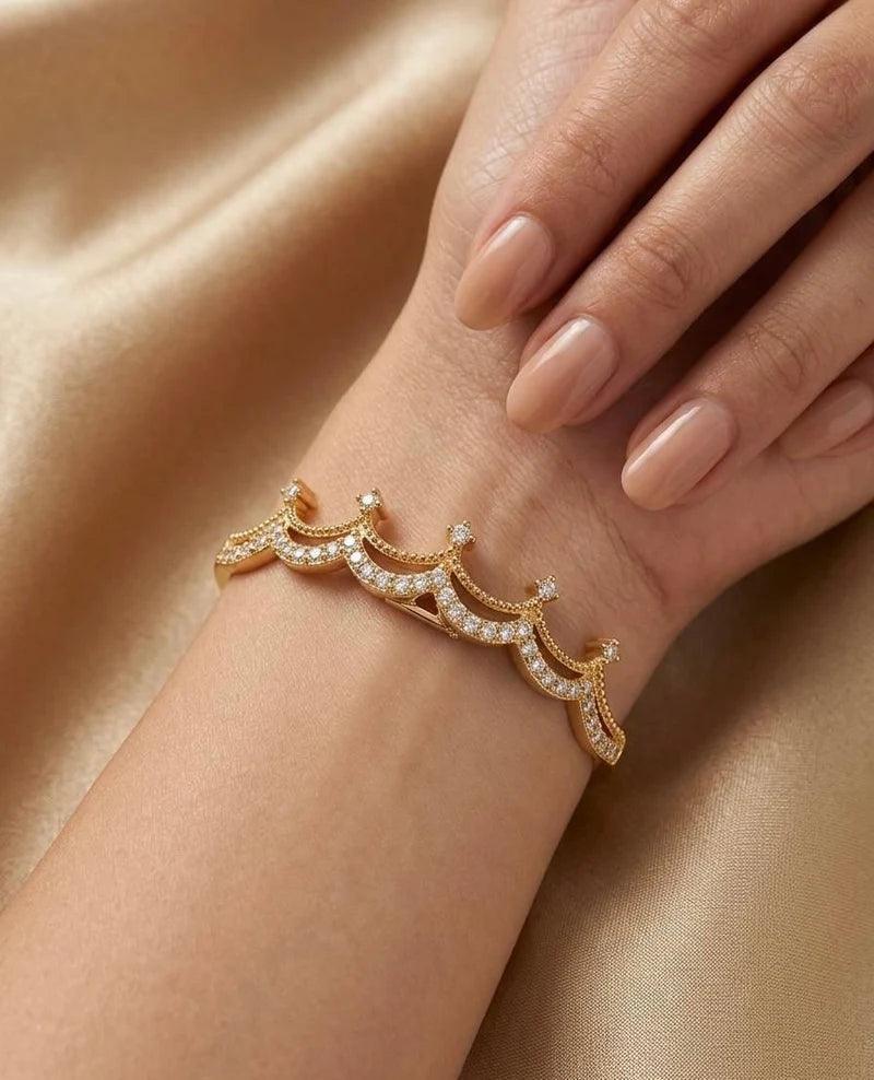 Gold bracelet with diamonds on a wrist against a beige fabric background